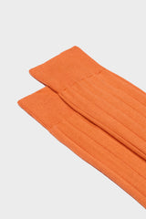 Close-up of the ribbed knit and hand-linked toe on Bresciani Massimo socks, in a solid orange color.
