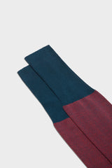 Close-up of the herringbone pattern and the high cuff on Bresciani Giulio socks, in a red peacock color.