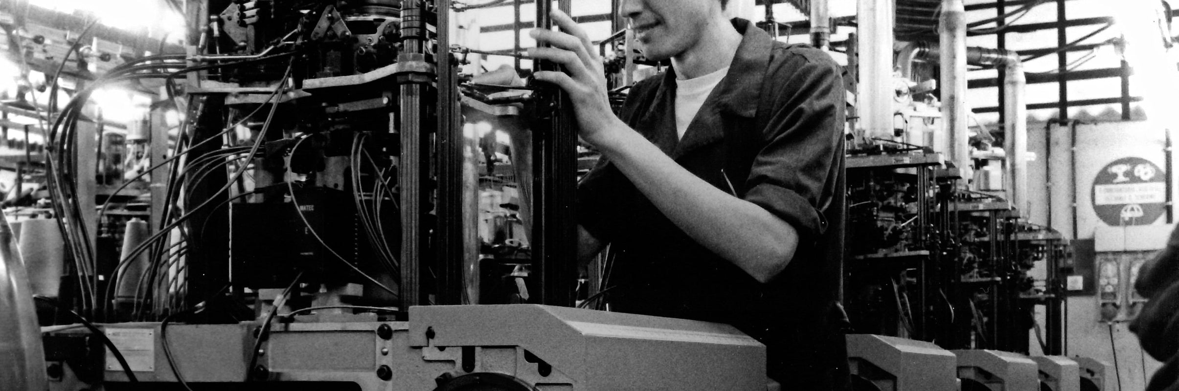 A Bresciani craftsman from the 1970s working on a traditional knitting machine, highlighting the brand's heritage.