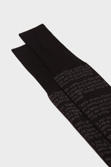 Close-up of the black cotton sock with text from Dante's Divine Comedy printed, highlighting the hand-linked toe and ribbed cuff.