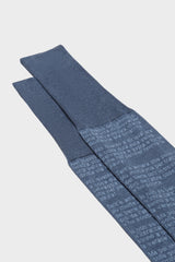 Close-up of the blue cotton sock with white text from Dante's Divine Comedy printed, highlighting the hand-linked toe and ribbed cuff.