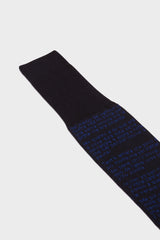 Close-up of the navy cotton sock with blue text from Dante's Divine Comedy printed, highlighting the hand-linked toe and ribbed cuff.